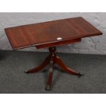 A mahogany drop leaf lamp table on casted brass claw feet