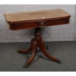 A 19th century mahogany fold over tea table in the manner of William Trotter. Raised on scroll