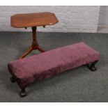 An early 20th century mahogany wine table, along with an upholstered footstool with ball and claw