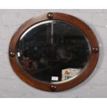 An oval bevelled edged wooden framed mirror (59cm x49cm)