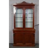 A large Victorian mahogany bookcase with shaped pediment and carved corbels. Converted to a