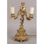 A French gilt bronze three branch tablelamp. With leaf moulded sconces and raised on a column plinth