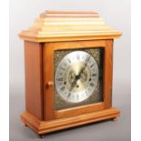 A modern mahogany cased mantle clock with brass dial and roman numeral markers. (Height 37cm).