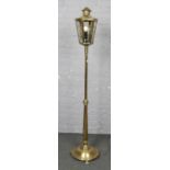 A brass floor standing lantern, converted to electric, with lion paw feet. (Height 186cm).