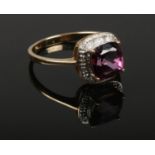 A 9ct gold cluster ring set with a large cushion cut purple stone under a border of diamonds. 2.9