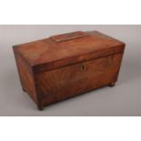 A mahogany tea caddy raised on small brass ball feet.