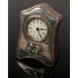 An Edwardian silver fronted dressing table clock by Boots Pure Drug Company. Embossed with cherubs