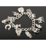 A silver charm bracelet with silver charms to include horse shoe, heart lock, animals etc, 40.5g.