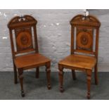 A pair of Victorian carved mahogany hall chairs. With swan neck cresting rails and raised on