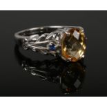 A 9ct white gold citrine and sapphire dress ring with open scroll shoulders. 4.7 grams gross weight,