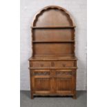 A carved oak Old Charm dresser with dome top.