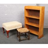 A wooden open bookcase, along with a modern footstool and one other.