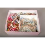 A large box of costume jewellery beads and necklaces.
