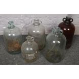 Four glass demijohn bottles along with a similar jug example etc.