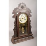 A mahogany Ansonia Clock Company gingerbread clock, with Roman numeral markers, chiming on a