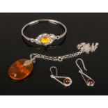 A collection of silver mounted amber jewellery including a bangle, pendant on chain and pair of