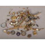 A tin of assorted dress jewellery and collectables including gold front and back locket, ladies