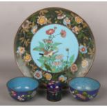 A Japanese Meiji period cloisonne dish decorated with a bird, two similar small bowls and a