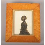 A c19th maple framed silhouette of a maiden. Worming to bottom of frame.