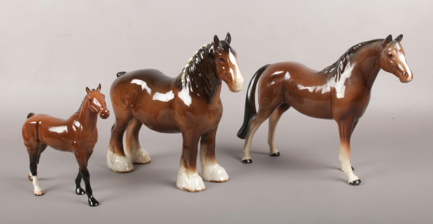 Three ceramic figures of horses, to include Beswick shire horse, Royal Doulton and Melba Ware.