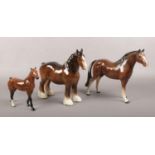 Three ceramic figures of horses, to include Beswick shire horse, Royal Doulton and Melba Ware.