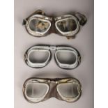 Three pairs of vintage motorcycle goggles.