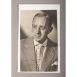 A monochrome photograph, signed by actor Alec Guinness, dated 1973.