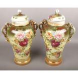 Two transfer printed twin handled vases with lids decorated with flowers. (45cm tall) Both vases