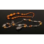 Two Eastern white metal and amber bead necklaces.