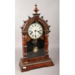 An carved mahogany American gingerbread clock, with Roman numeral markers, chiming on a coiled gong.