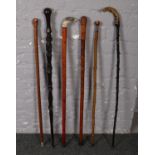 Five walking sticks to include carved hardwood example decorated with snakes, mining, carved bird