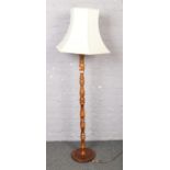 A wooden standard lamp with shade