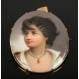 A miniature portrait of a maiden painted on porcelain in yellow metal mount.