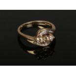 A 9ct gold and diamond crossover ring. Set with three champagne diamonds under channel set