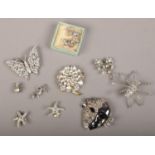A case of vintage white paste costume jewellery including spider, butterfly and spray brooches.