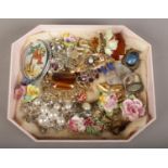 A tray of vintage costume jewellery brooches including porcelain spray brooches.