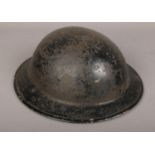 A WWI brodie helmet with folded rim and original liner and chin strap.