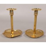 A pair of Arts & Crafts patent brass candlesticks. With expanding sconces and raised on pierced