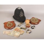 A group of collectables, to include police helmet, military plaques, bank notes etc.