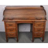 A 1940s oak roll top desk raised on square supports, 122cm wide, 100cm high, 68cm deep.