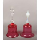 Two Victorian cranberry glass bells, one with vaseline glass handle. Largest 32cm. Vaseline bell