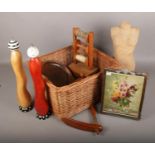A basket of treen items, to include large pepper mills, bowls, photograph frame etc.