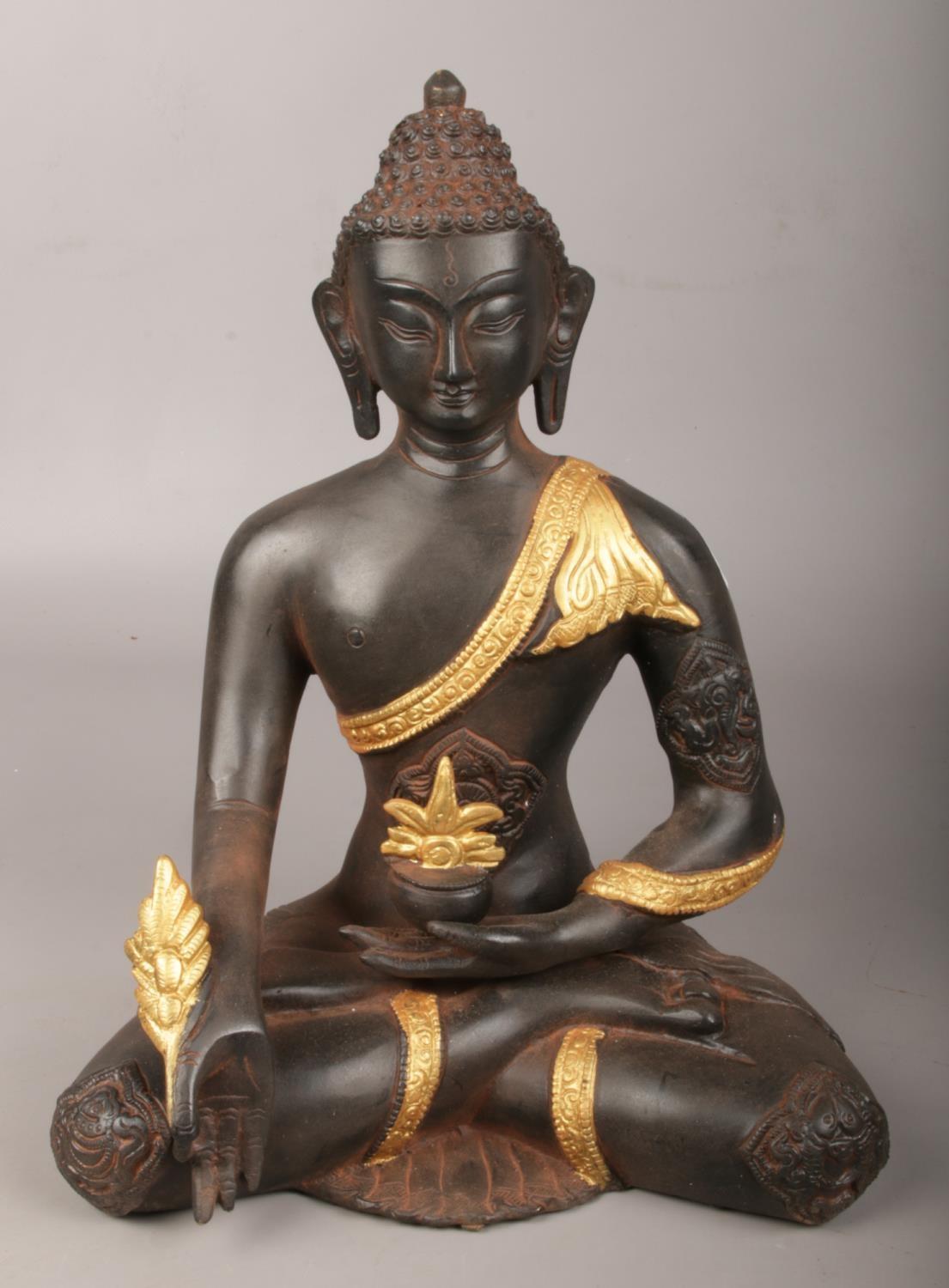 A metal seated medicine Buddha with gilt decoration. (Height 29cm). Good.