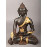 A metal seated medicine Buddha with gilt decoration. (Height 29cm). Good.