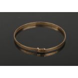 A 9ct gold baby's bangle decorated with engine turned engraving., 1.65 grams.