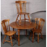 A circular beech dining table along with 3 matching dining chairs.