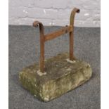 A cast iron boot scrape in concrete base.