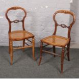 A pair of Victorian carved balloon back bedroom chairs with canework seats.