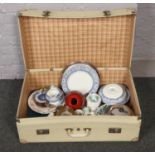 A suitcase of miscellaneous to include cabinet plates, quartz mantel clock, silver plate, ceramics