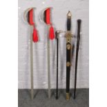 A bundle of swords and sticks to include ebonised walking stick example.